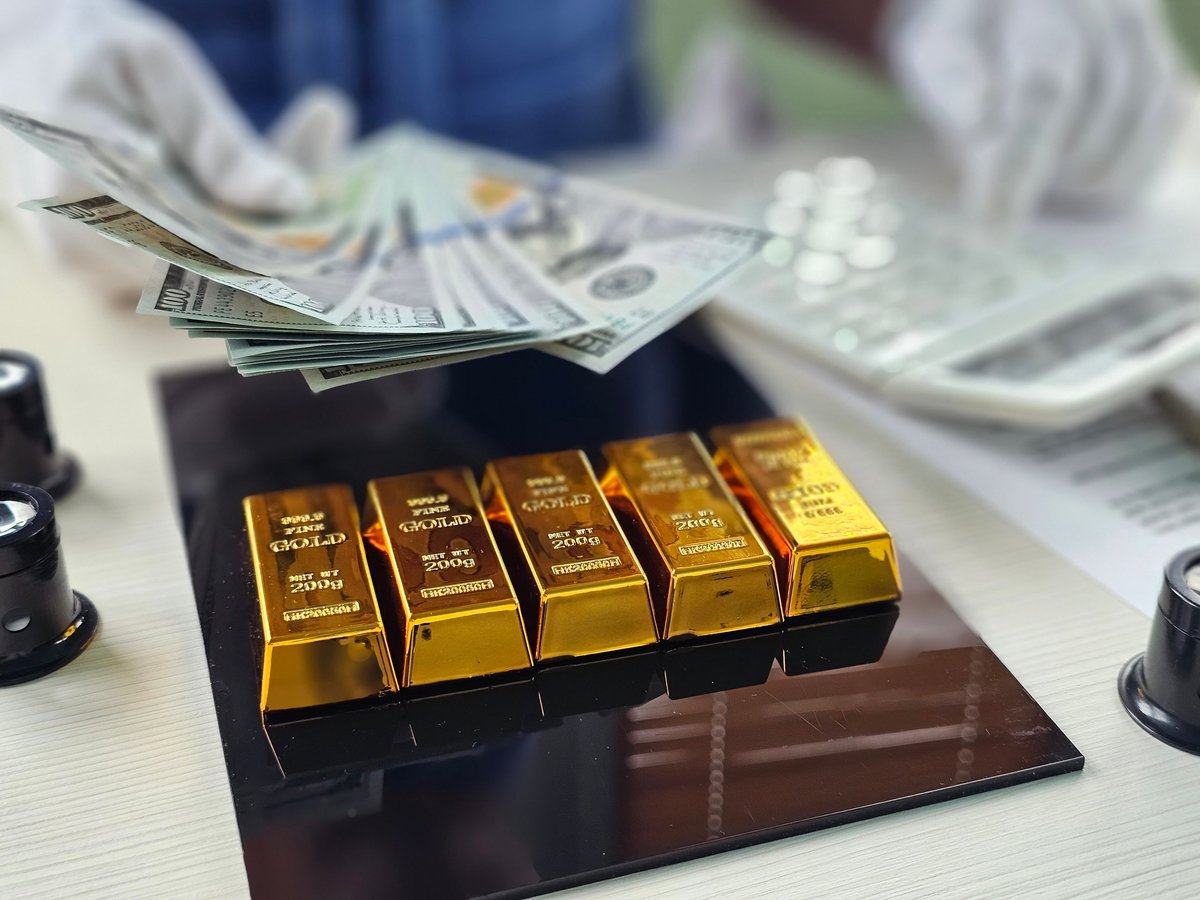 Exchanging cash for gold bars at an investment office.